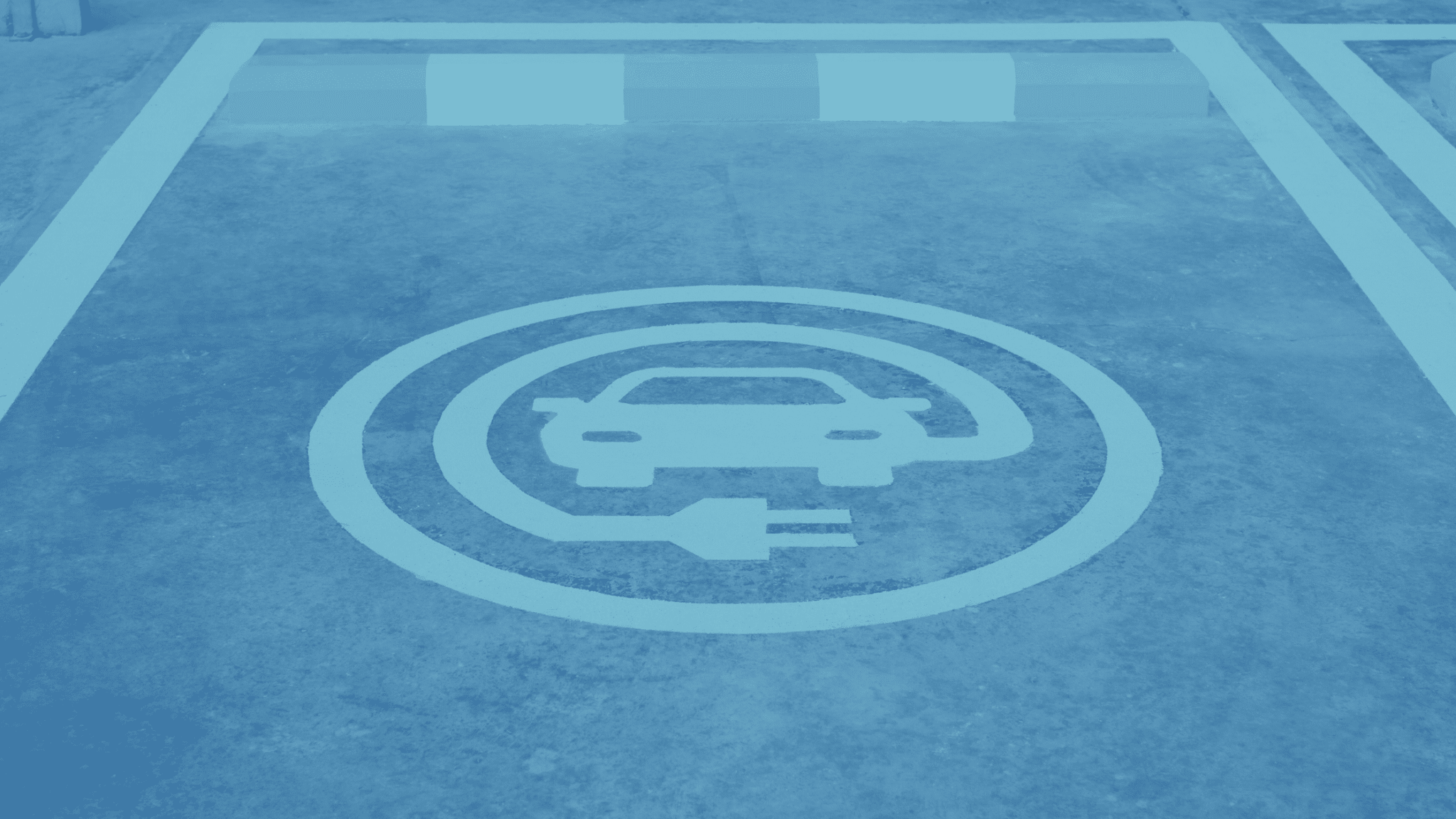 A parking spot with a painted symbol indicating it's designated for electric vehicle charging, ideal for commercial parking areas.