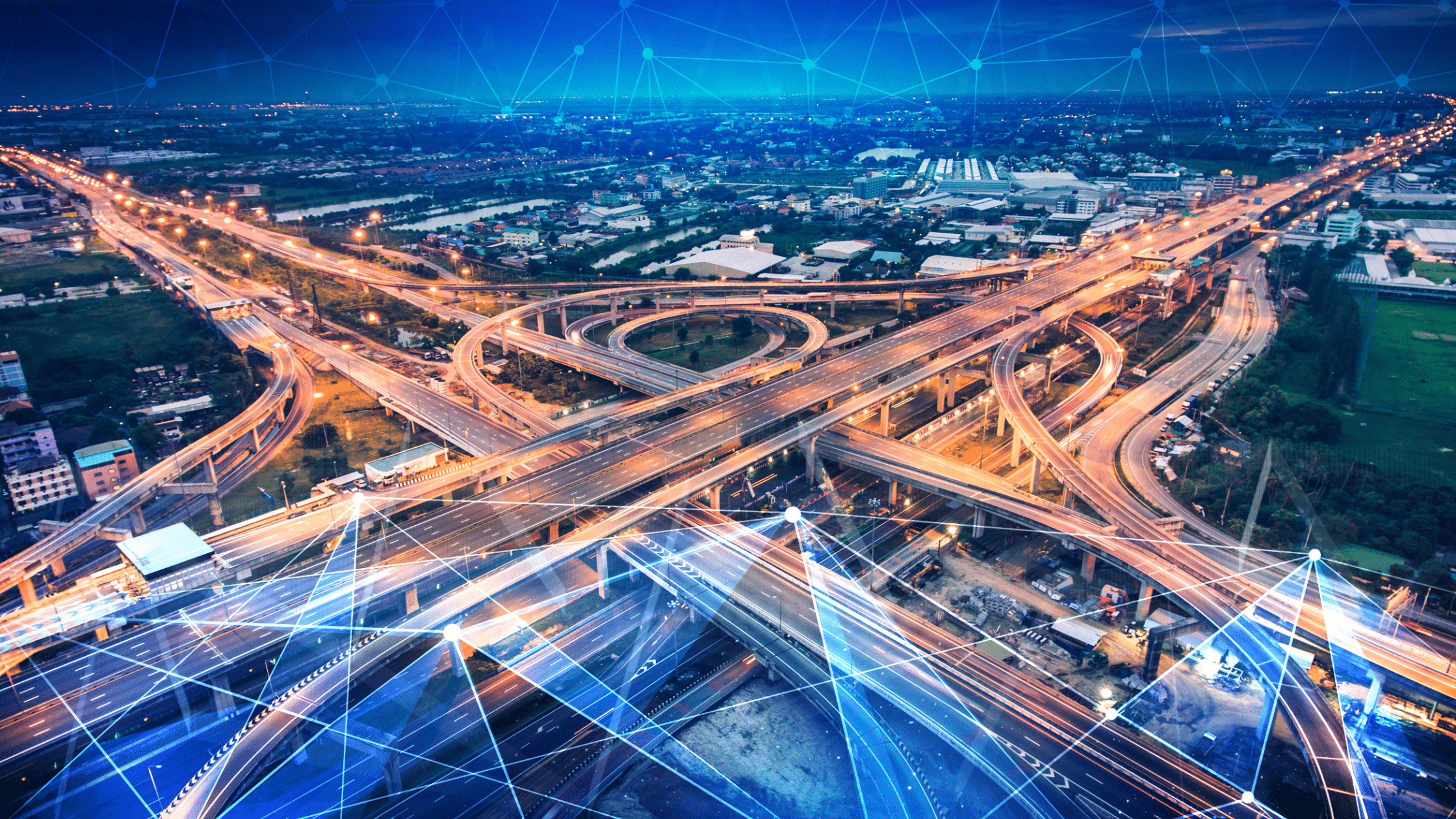 Aerial view of a complex highway interchange with illuminated roads and overpasses at night, overlaid with a blue digital network graphic, seamlessly integrated with advanced parking lot systems.